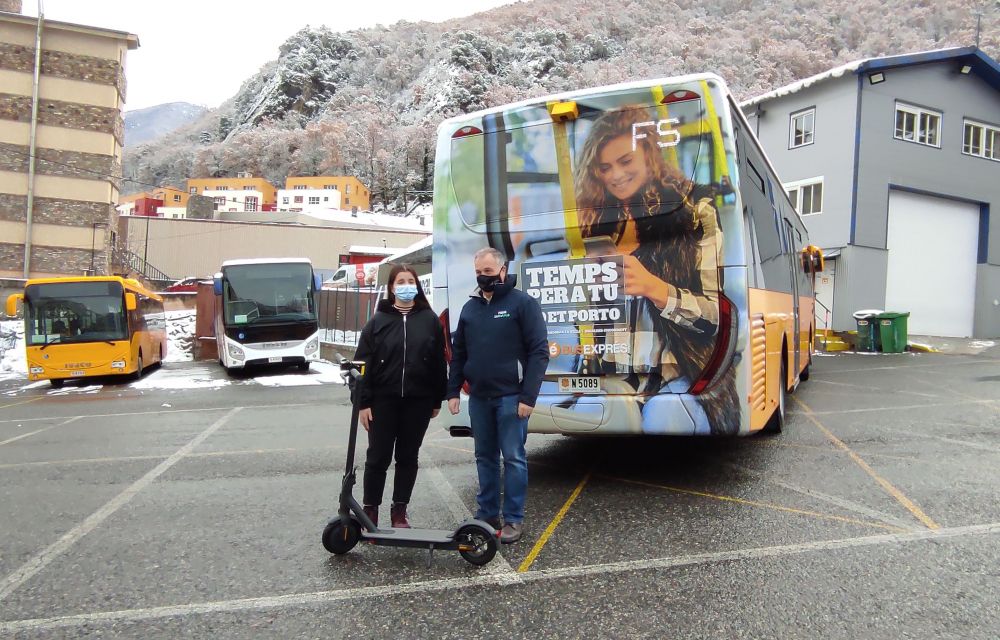 Bartumeu Gabriel amb la guanyadora d'un patinet elèctric per haver respost l'enquesta davant un bus amb el grafisme de la nova campanya.