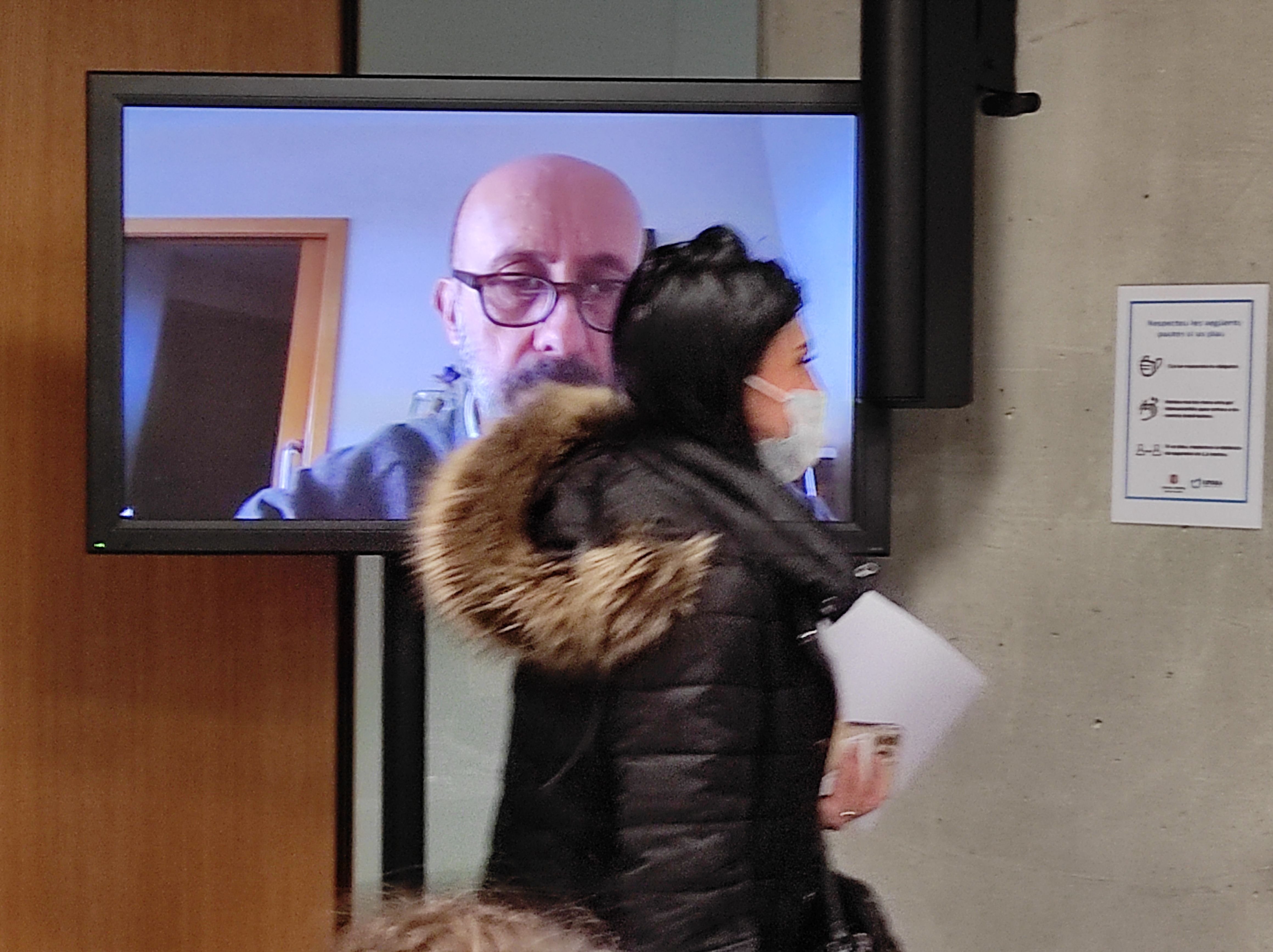 Carine Montaner passa per davant d'una pantalla on apareix Joan Martínez Benazet.