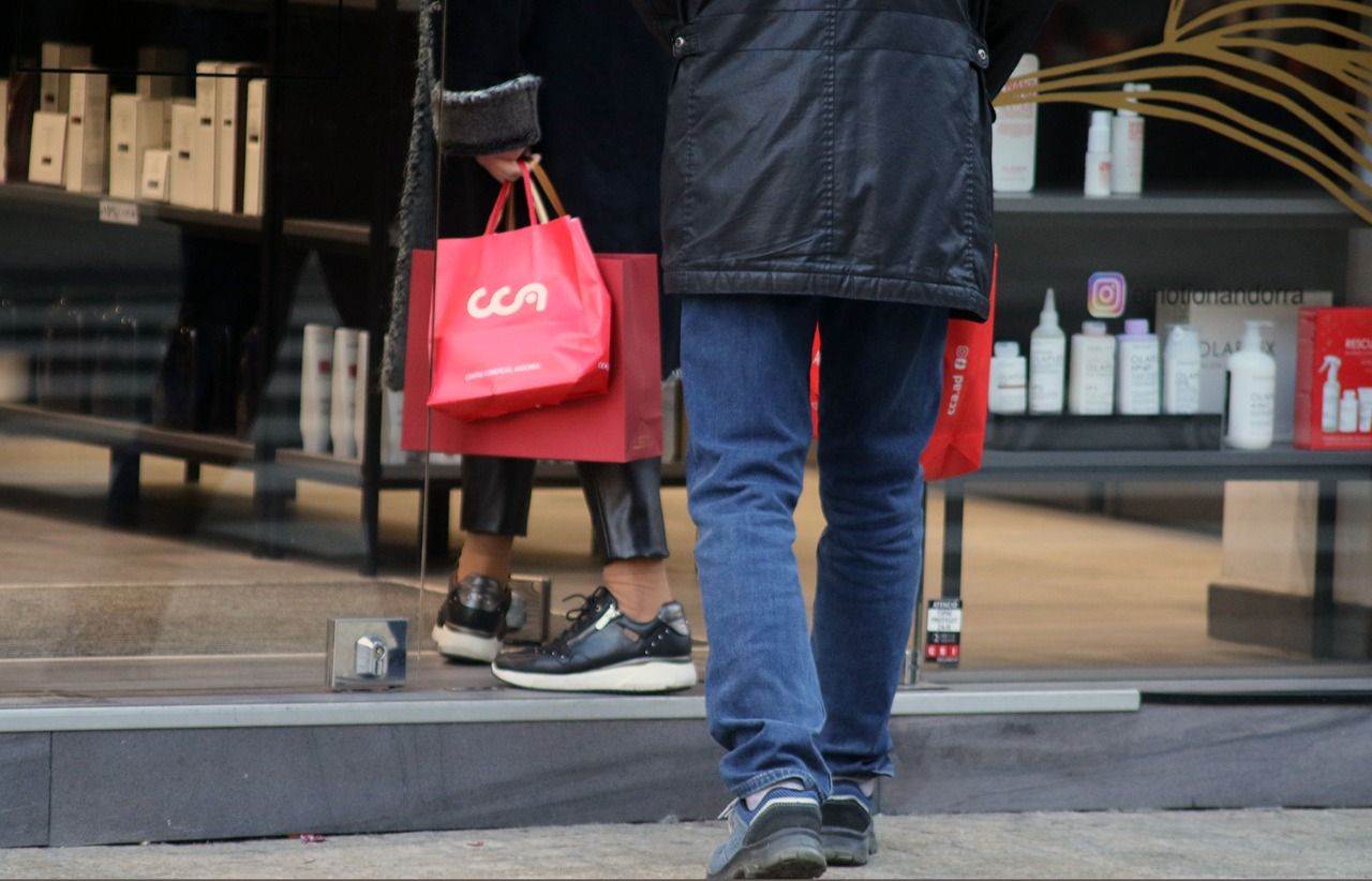 Un home amb bosses sortint d'un centre comercials.