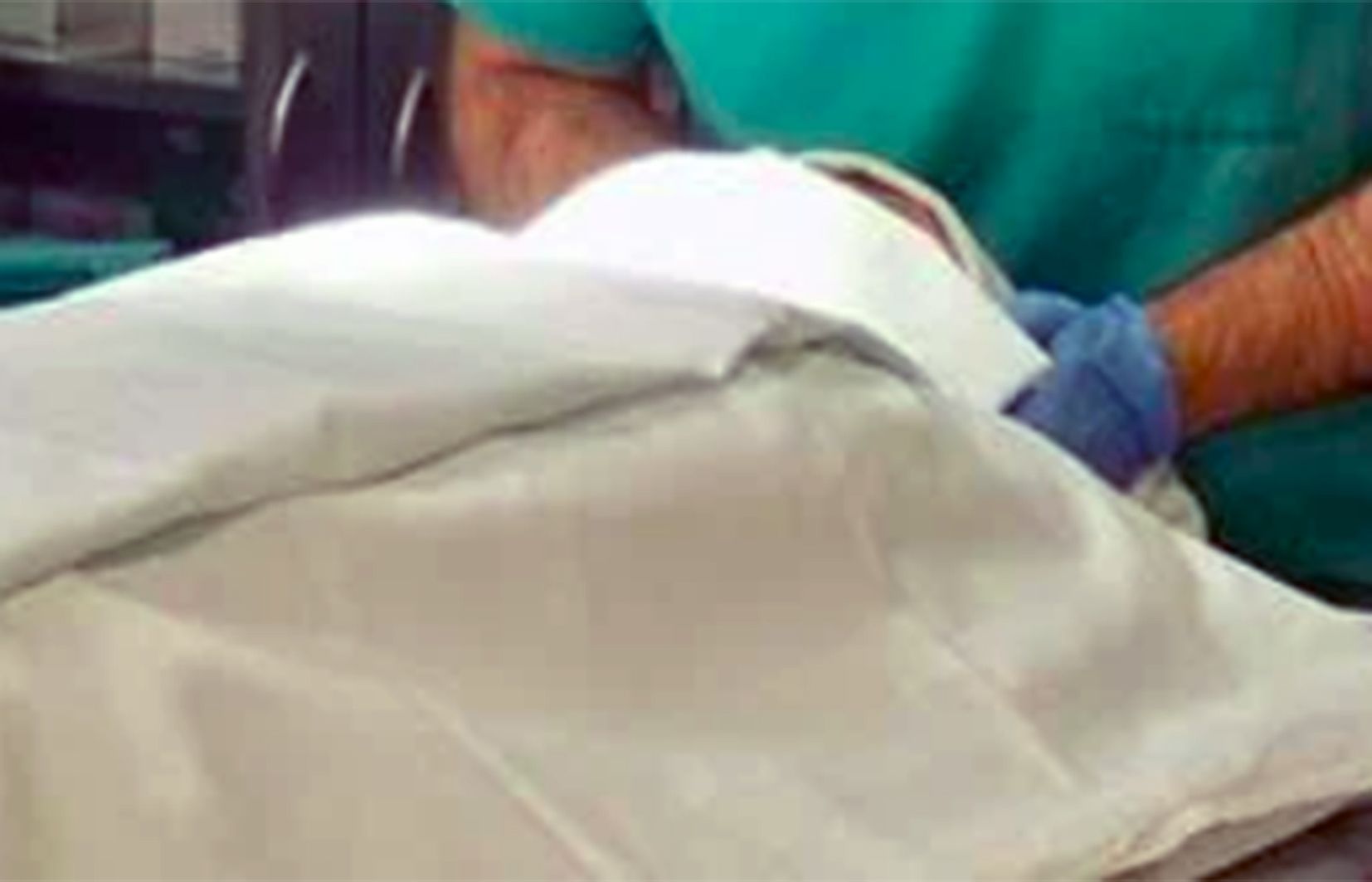 Un metge forense preparant-se per treballar amb un cadàver.