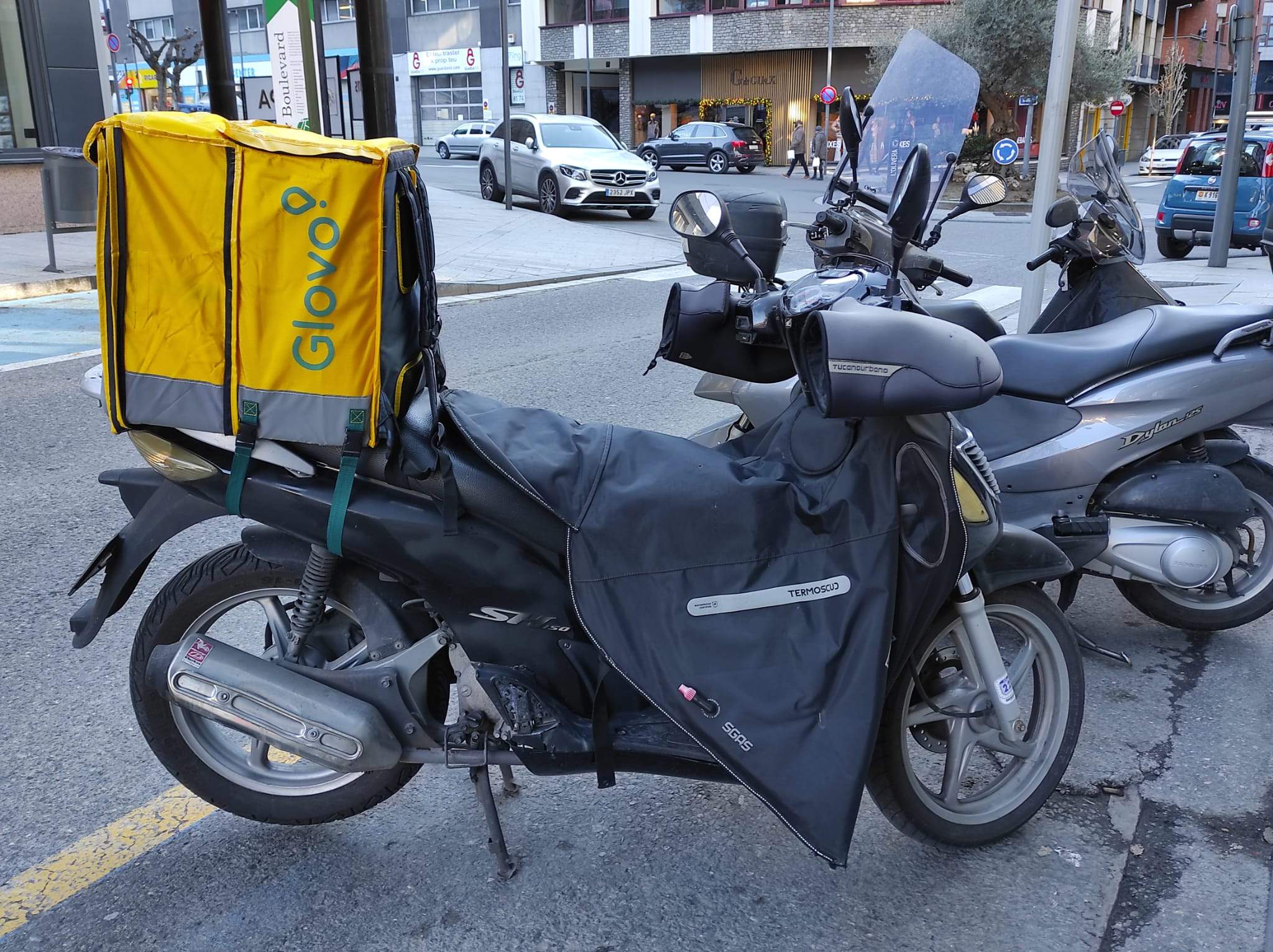 Una motocicleta amb 'equipament' de Glovo estacionada al carrer Maria Pla d'Andorra la Vella.