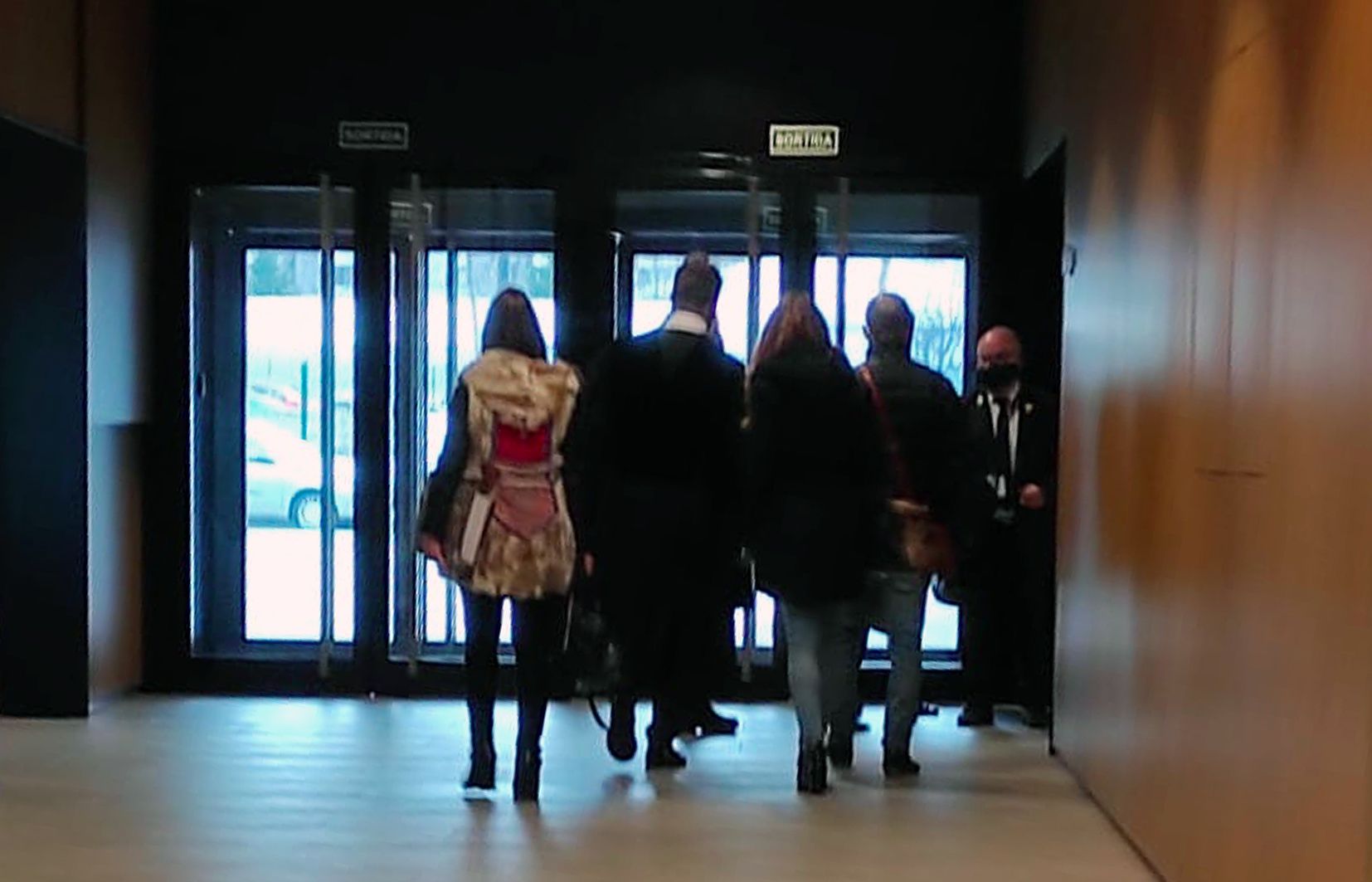 El docent i els seus acompanyants i advocats acudint cap a la sala de vistes.