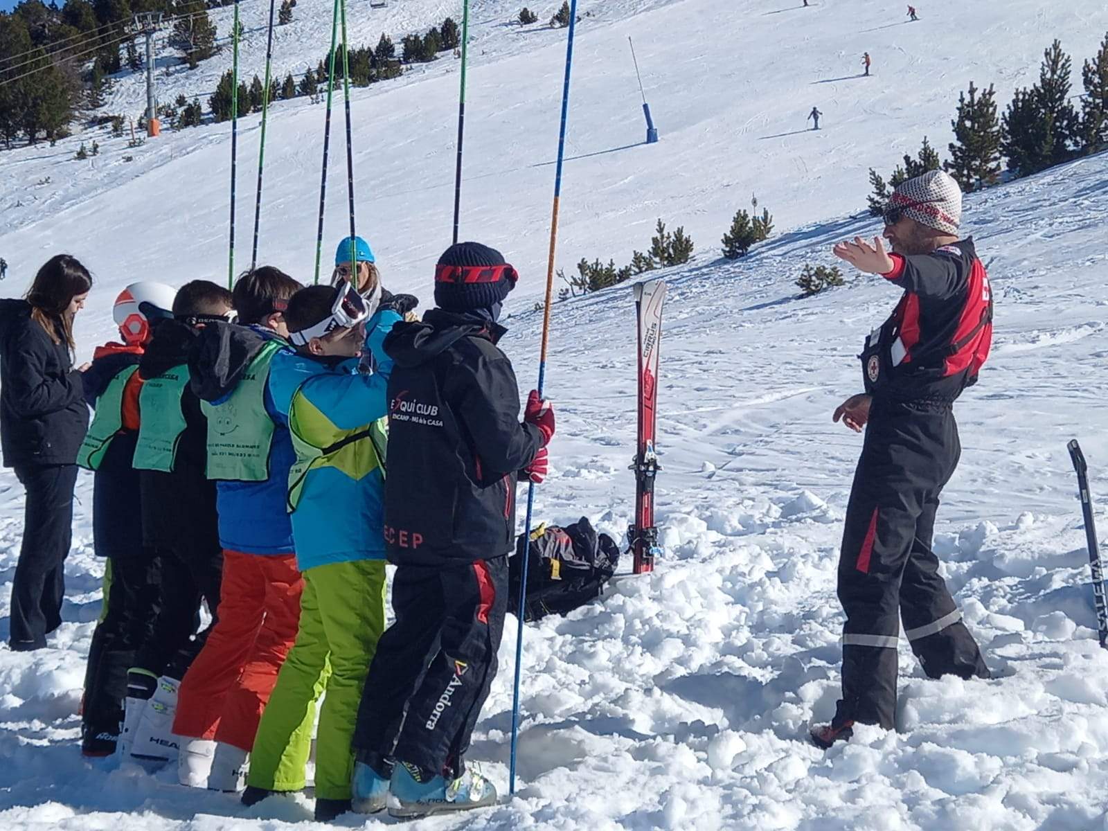 Els alumnes escolten les instruccions d'un monitor d'esquí.