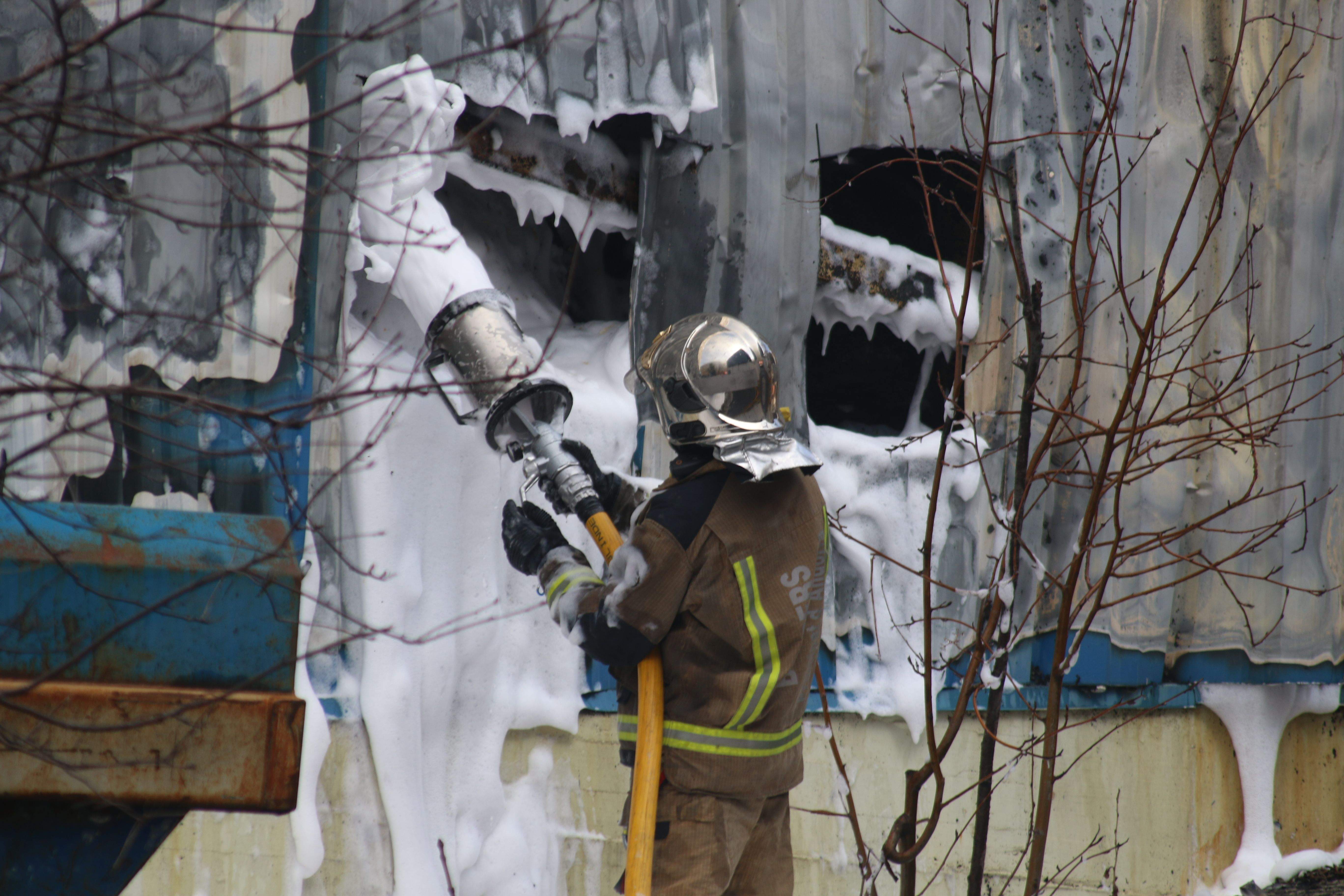 Un bomber fent tasques d'extinció de l'incendi.