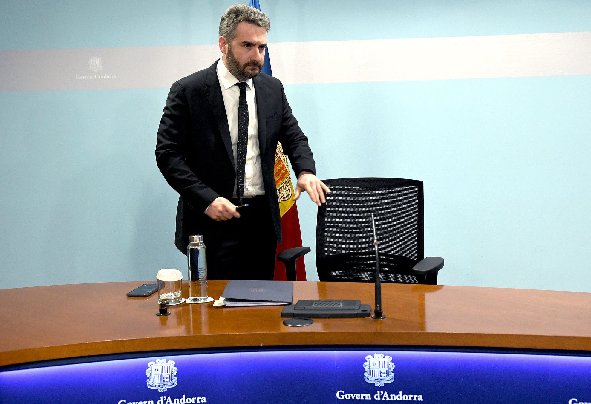 Jover, a punt de seure a la cadira de la taula de la sala de premsa.