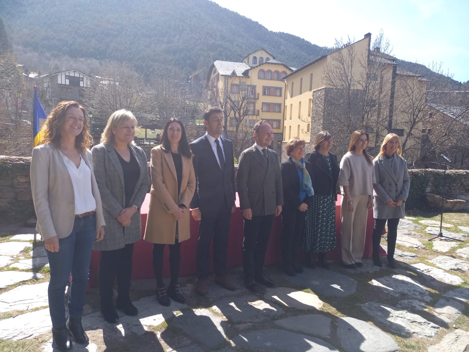 Foto de grup dels assistents a l'acte de signatura, amb l'hotel al fons.