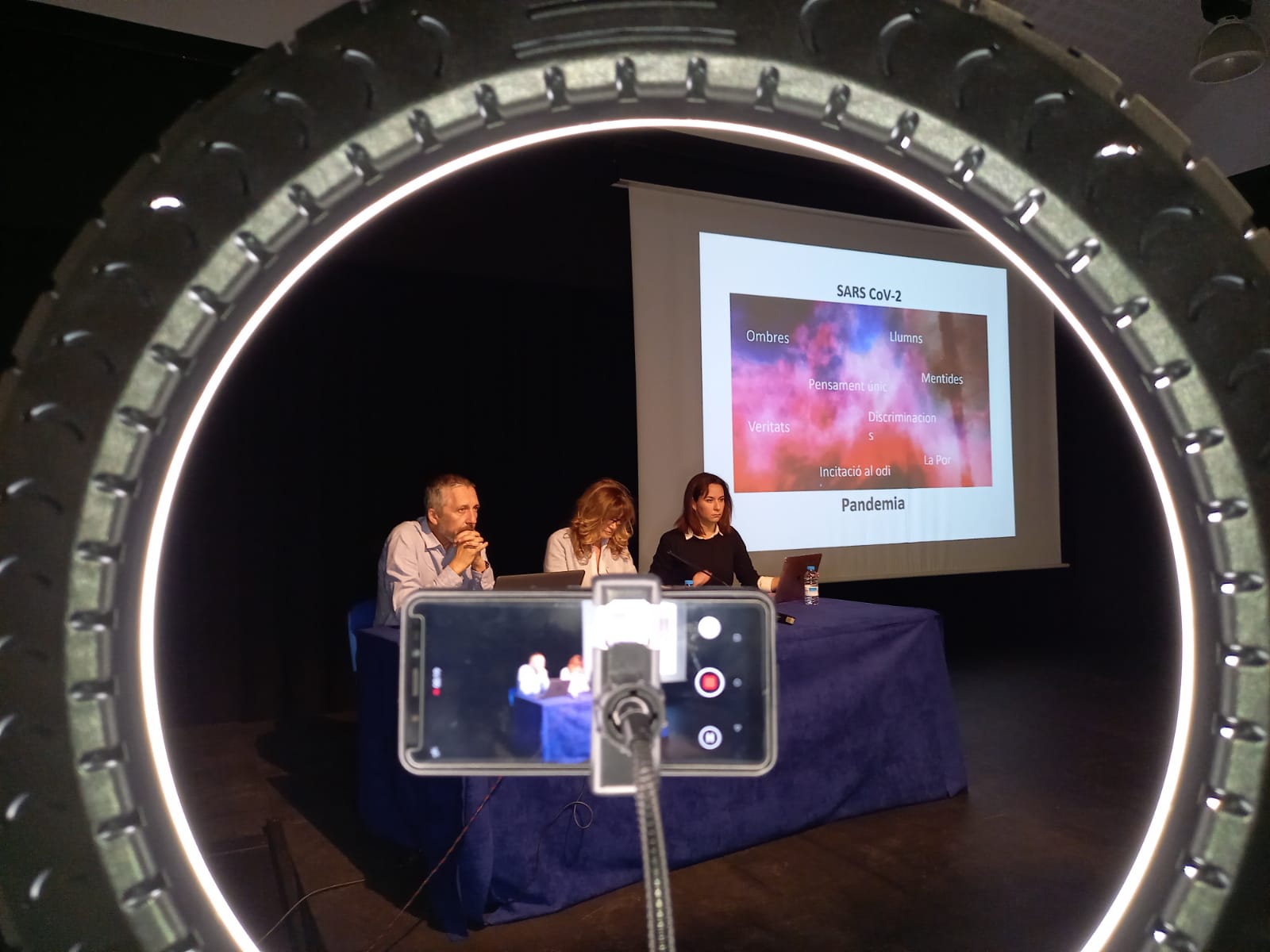Els ponents de la taula rodona a través del mòbil que gravava l'acte.