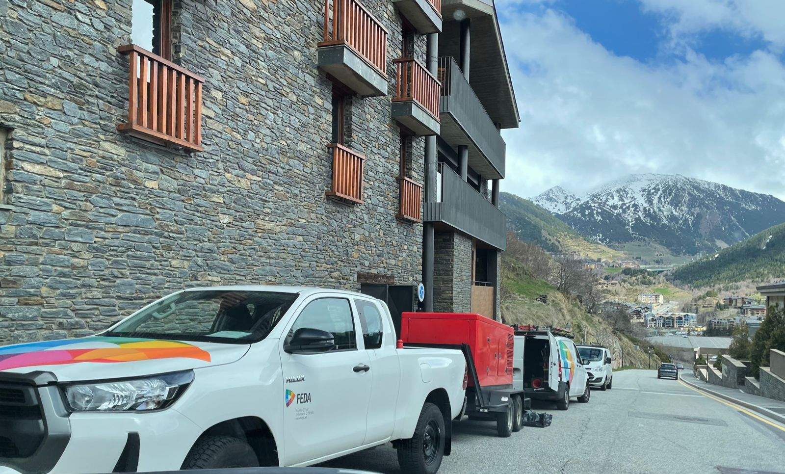 Una camioneta i un cotxe de FEDA a l'exterior de l'edifici on ha tingut lloc el sinistre.